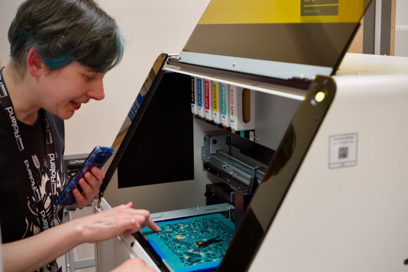 A person printing with a desktop UV printer